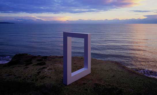Невозможная скульптура на скалистом берегу моря на рассвете